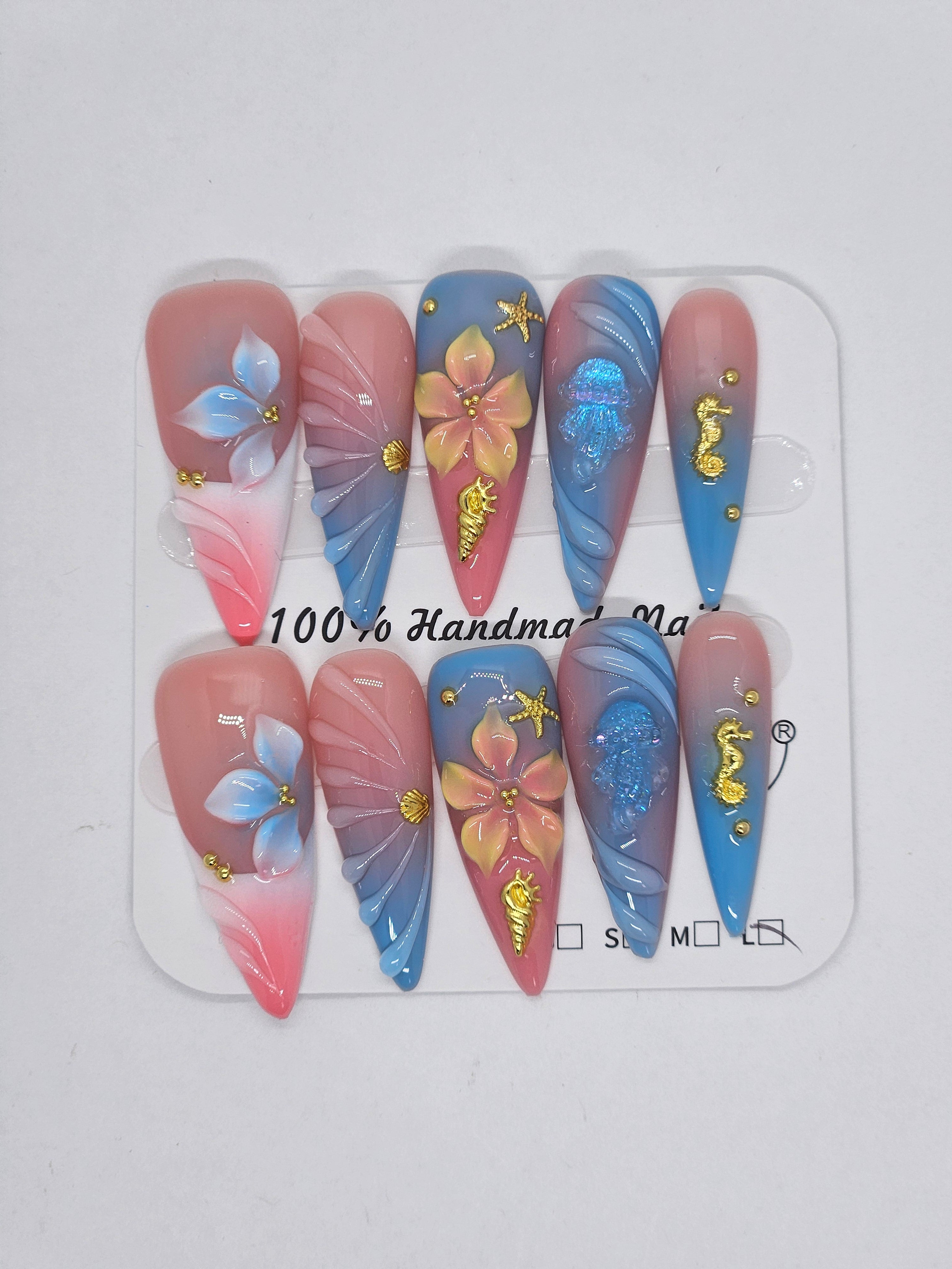 100% handmade stiletto press-on nails with pink and blue ombre gradient, 3D floral accents, gold seahorse, jellyfish, and starfish charms